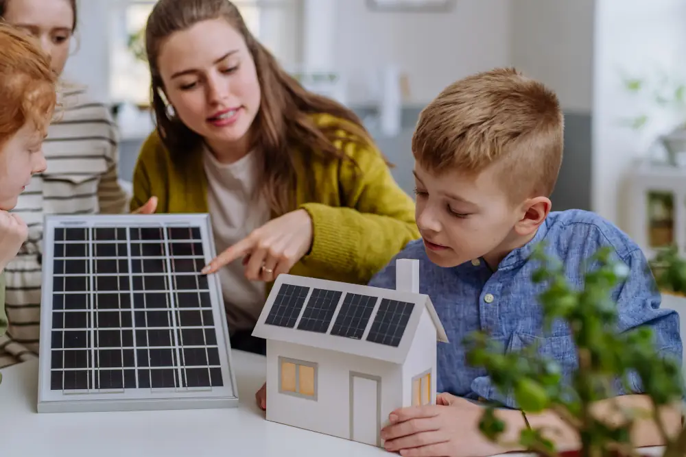 Catch the Sun and Power Your Home: Harnessing the Benefits of Solar Energy - Family at a table ( Dad, mom, son ) looking at scale models of solar panel and house with solar panels.