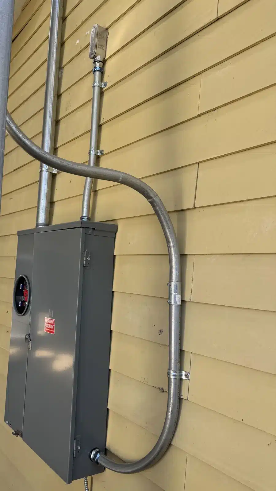 New outdoor electrical panel with metal conduit installed on a home in Merced, CA